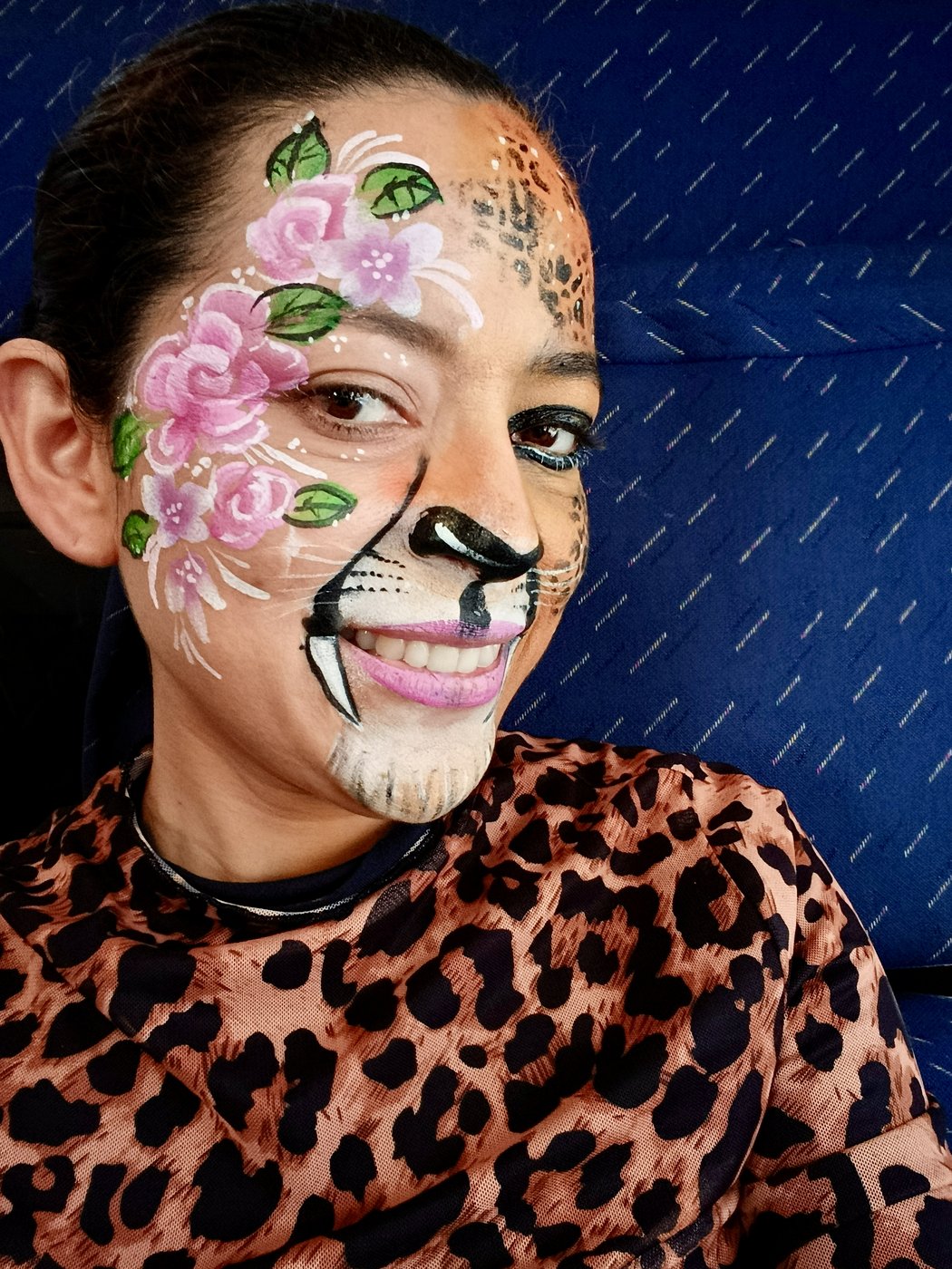 Maquillaje mitad leopardo con flores rosas en frente